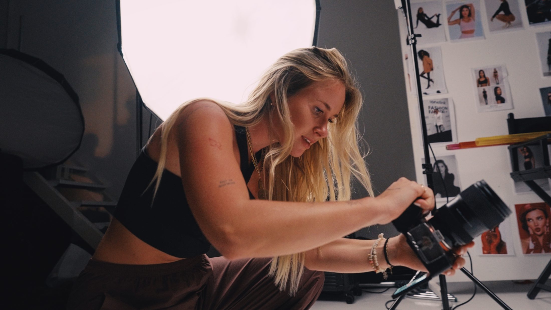 Jamie Fisch adjusting a camera on a studio set